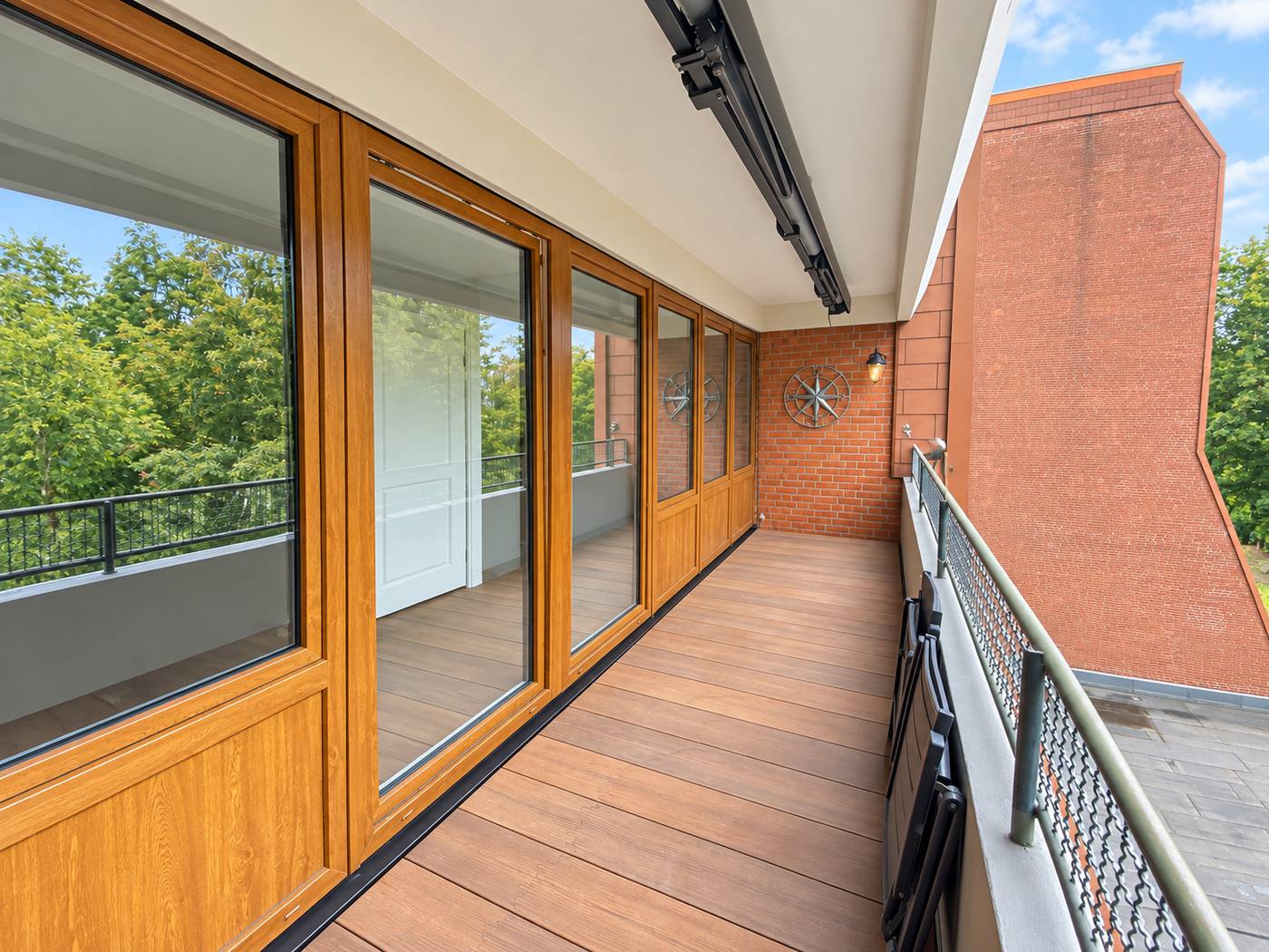 Fenster- und Türfront in Holzoptik an einem Balkon